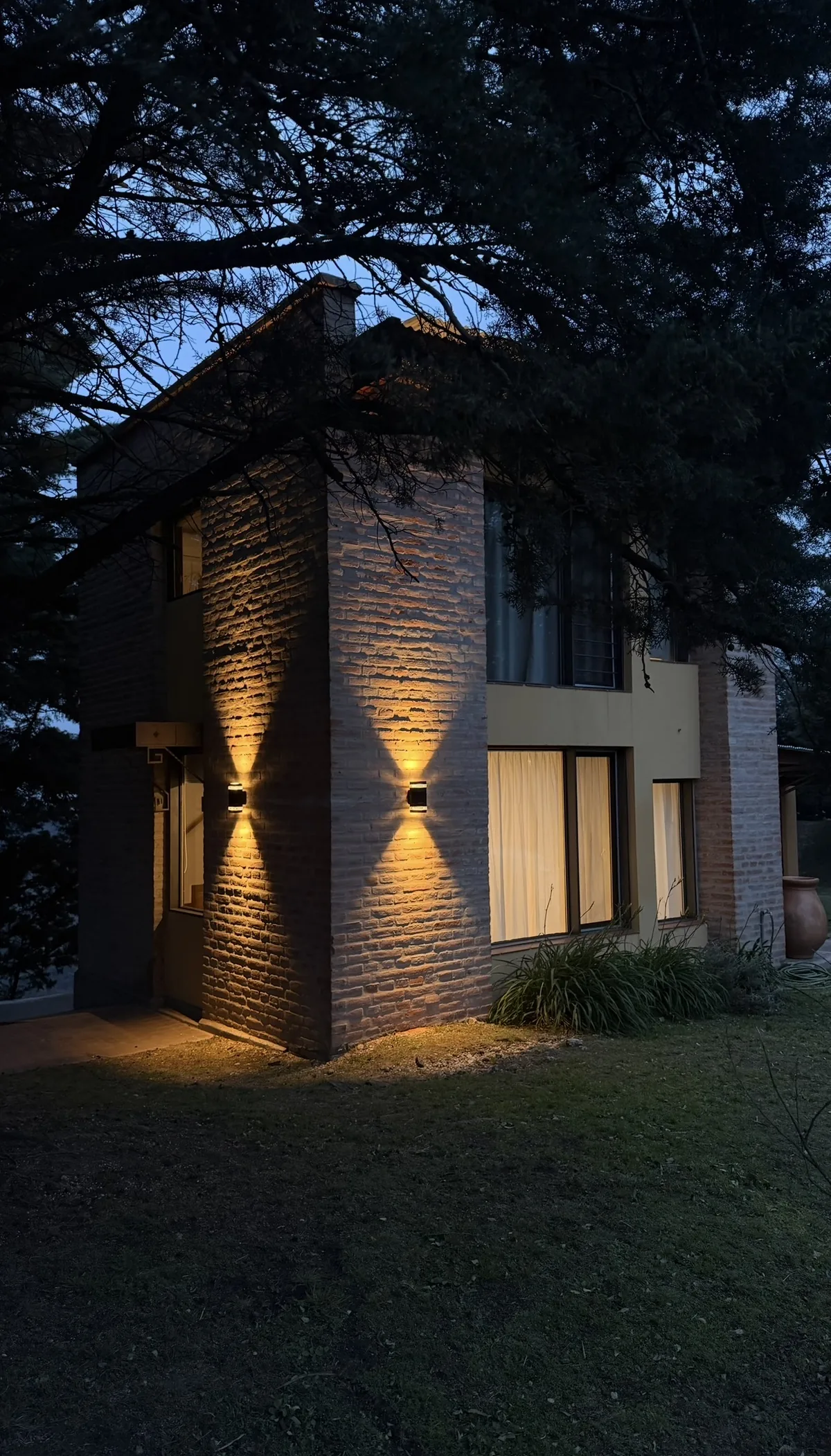 Fachada de la Casa Amarilla al anochecer, con luces cálidas