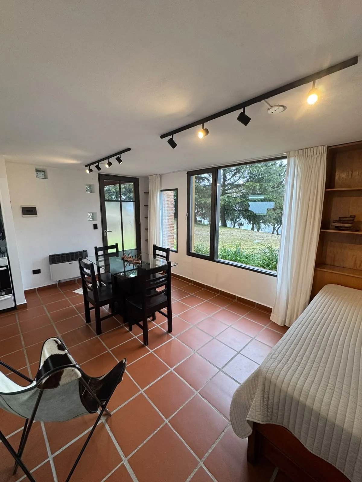 Living de la Casa Amarilla con ventanal a las sierras